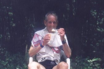 Runner sitting in a plastic lawn chair eating food