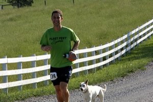 Runner in green shirt running on gravel road