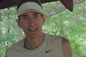 Runner with white visor on smiling at camera.