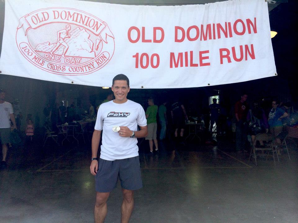 Finisher standing in front of Old Dominion banner