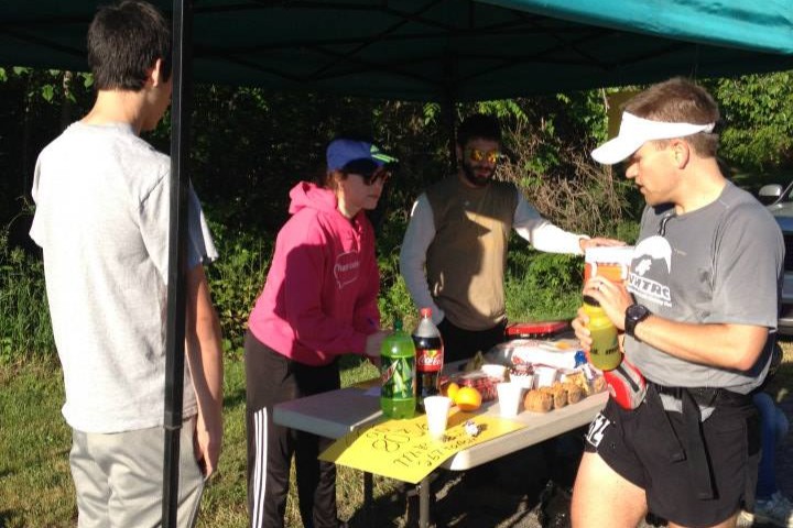 Runner stopping at an aid station and grabbing some food.