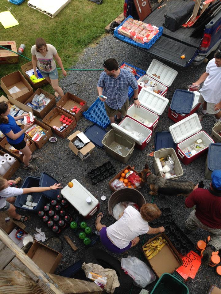 Coolers and boxes around a group of people, who are sorting through all the material