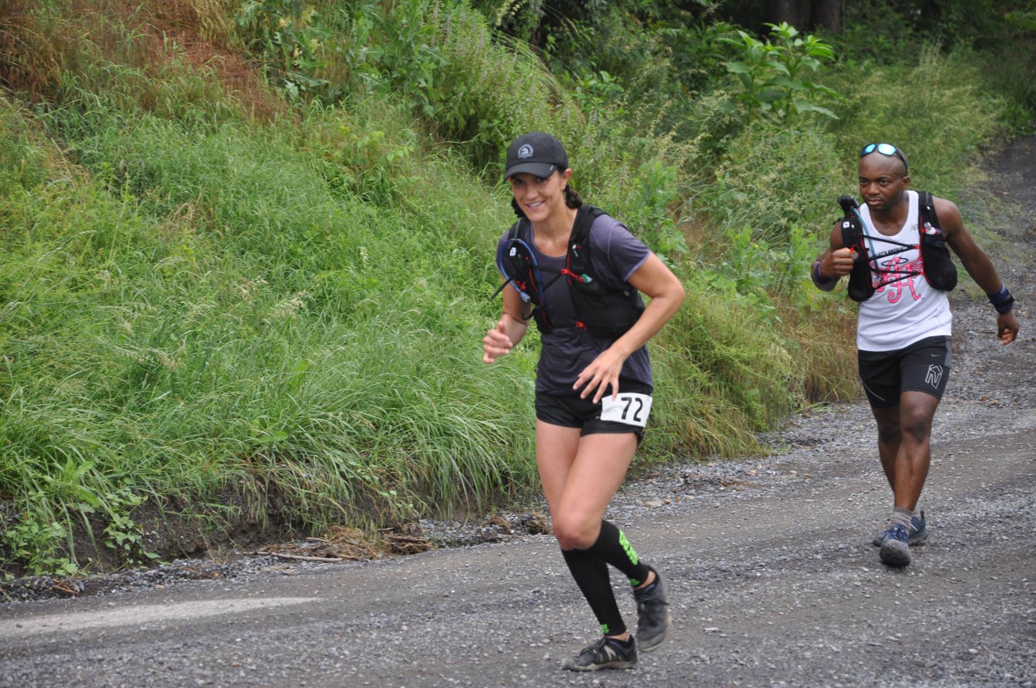 Bib 72 looks at the camera, another runner behind her.