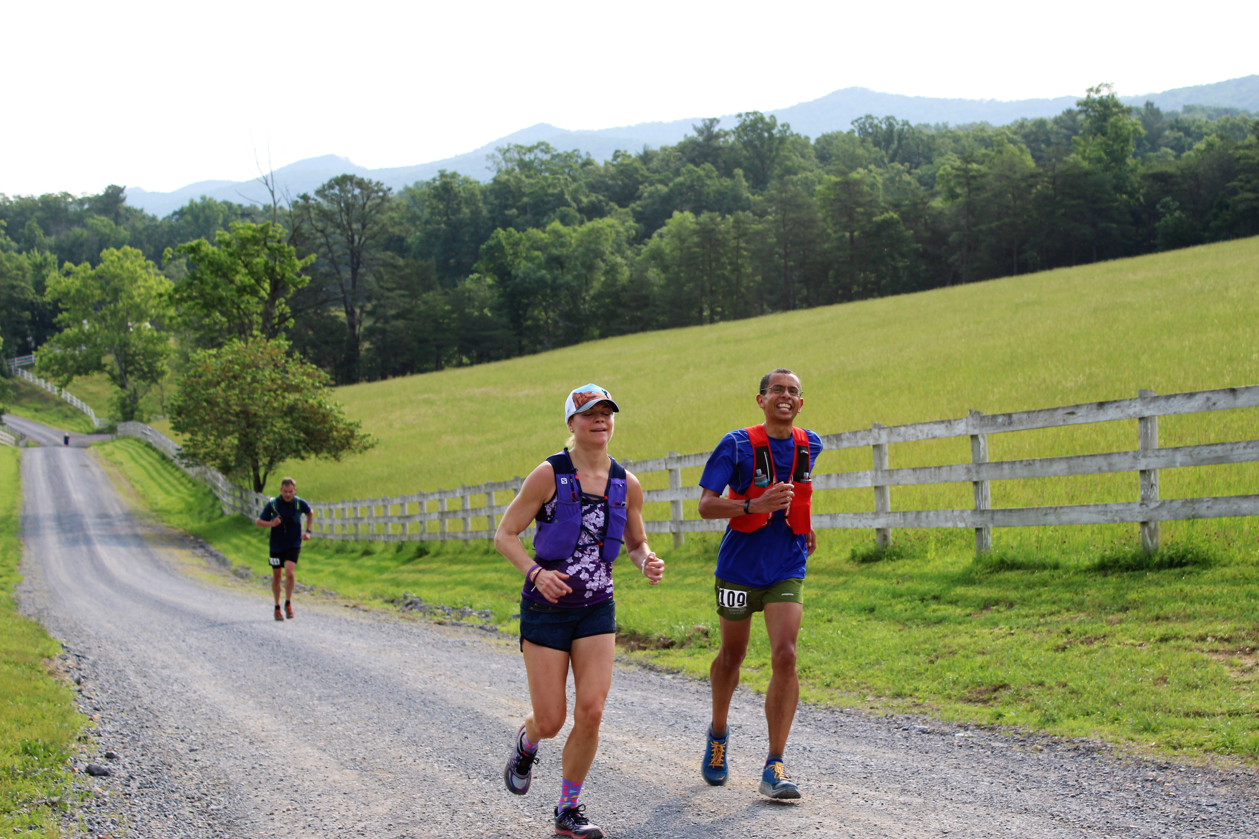 Sharon K, Andrea H, and another runner in the distance runs along the rolling gravel course