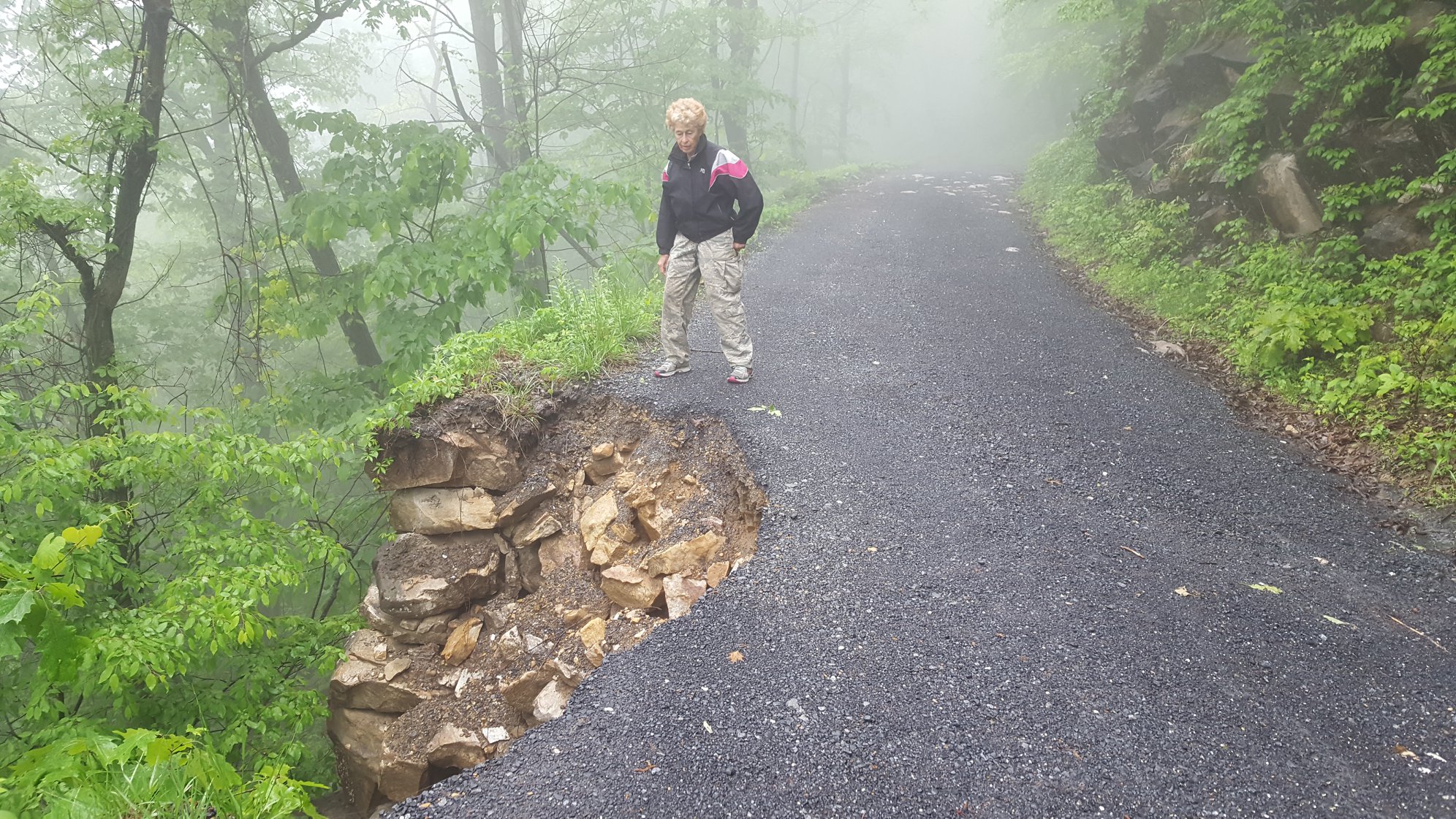 A women stands next to a washed out section of the course