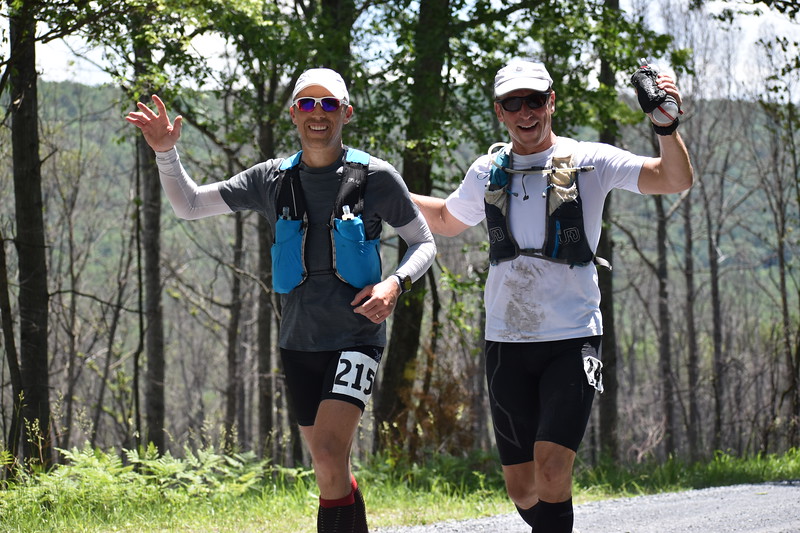 Runner sits in a chair to adjust their shoe at an aid station