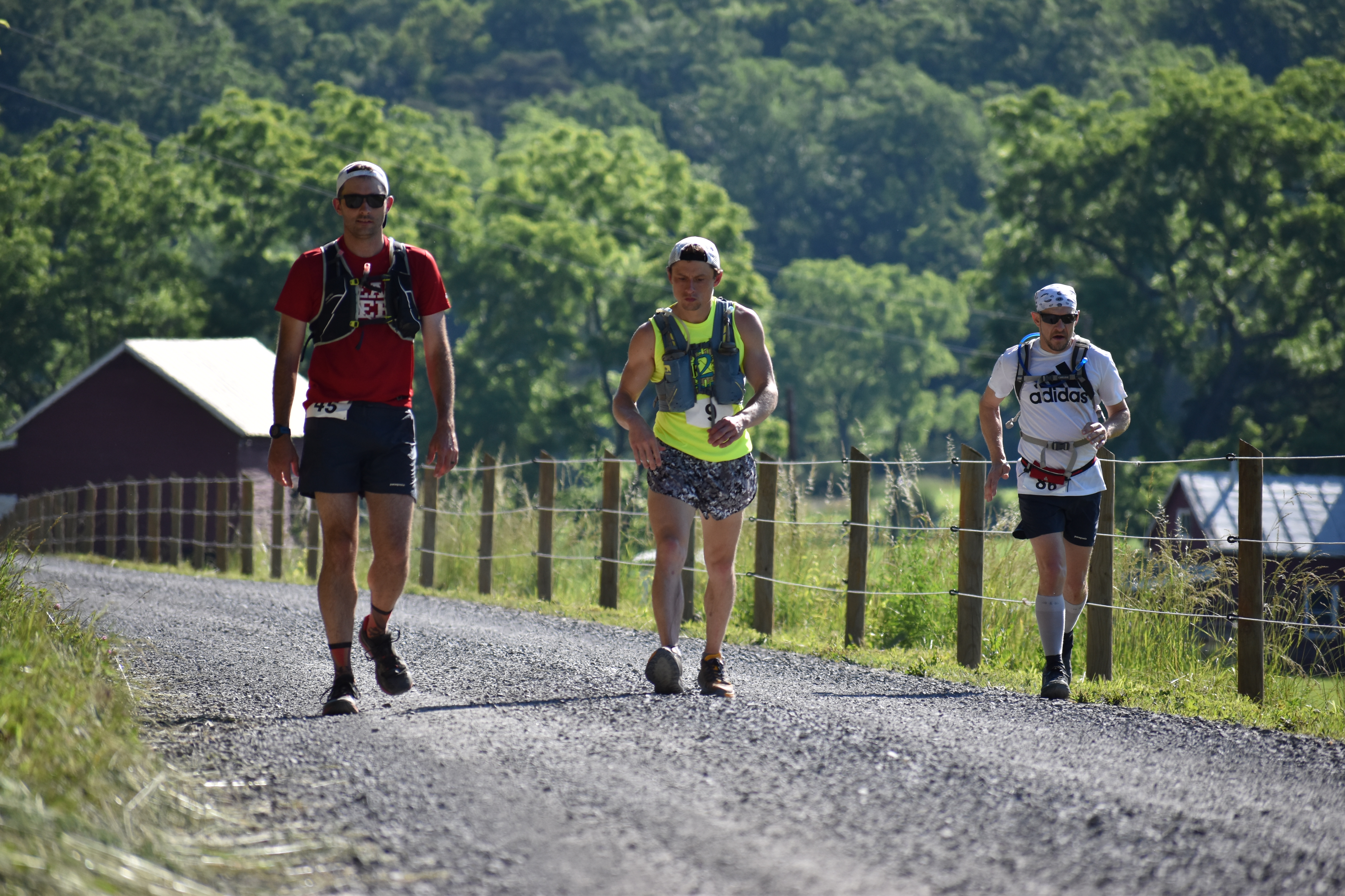 Ryan Goodman, Jesse Goodenough, Michael Bergquist running along a gravel road.