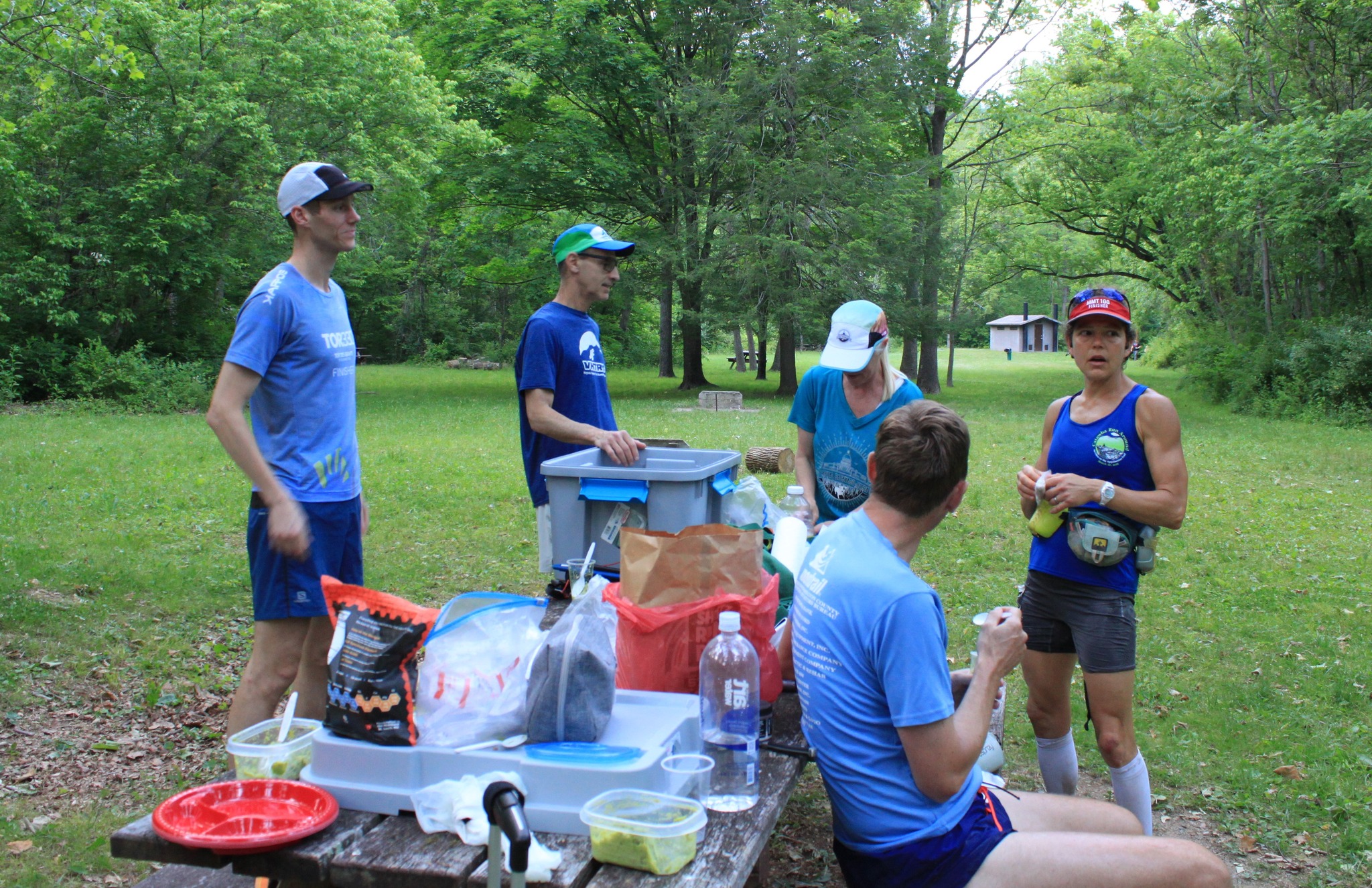 Runners around a picnic table receiving aid.  