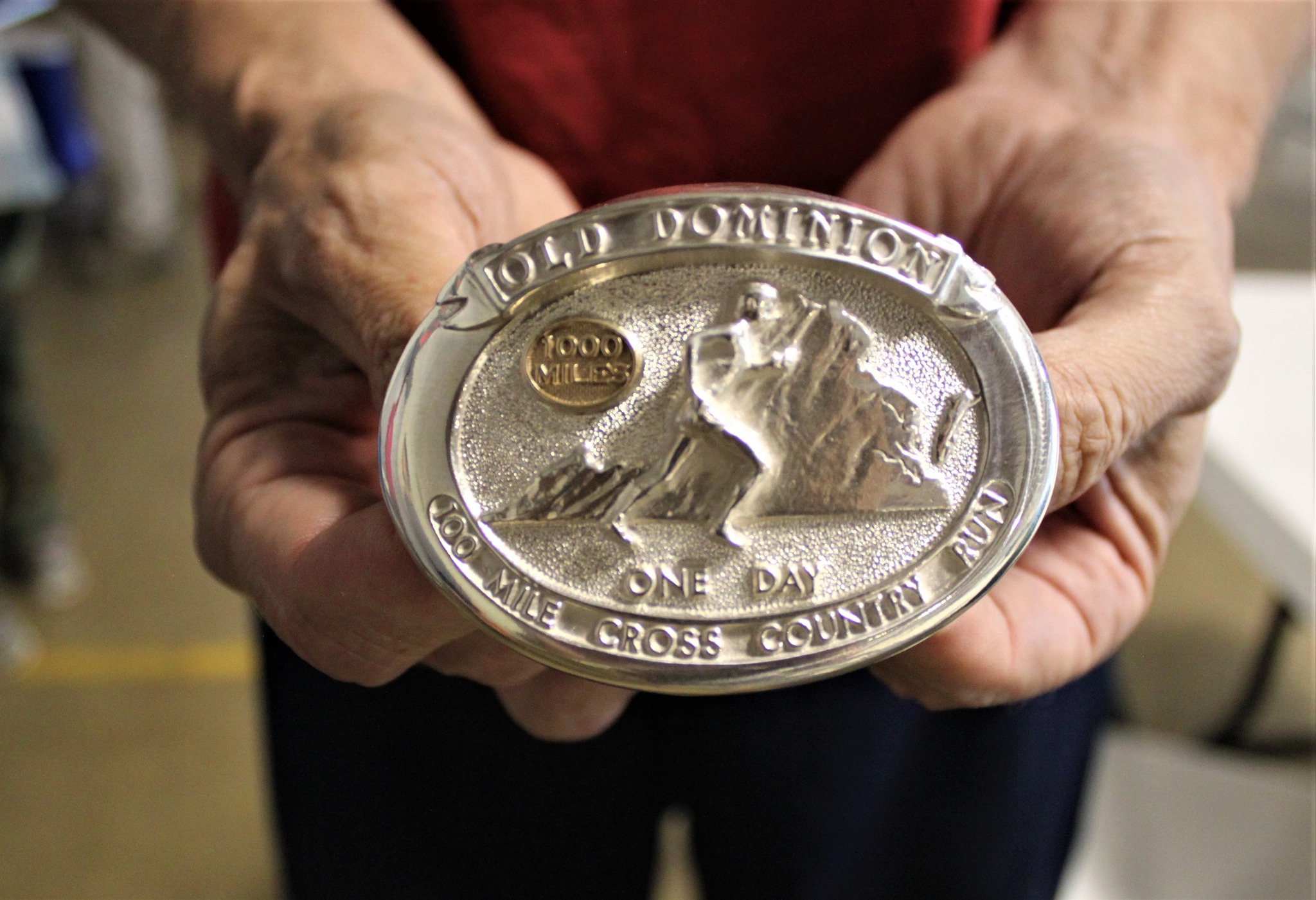 Silver buckle with Old Dominion emblem with a 1000 mile button.