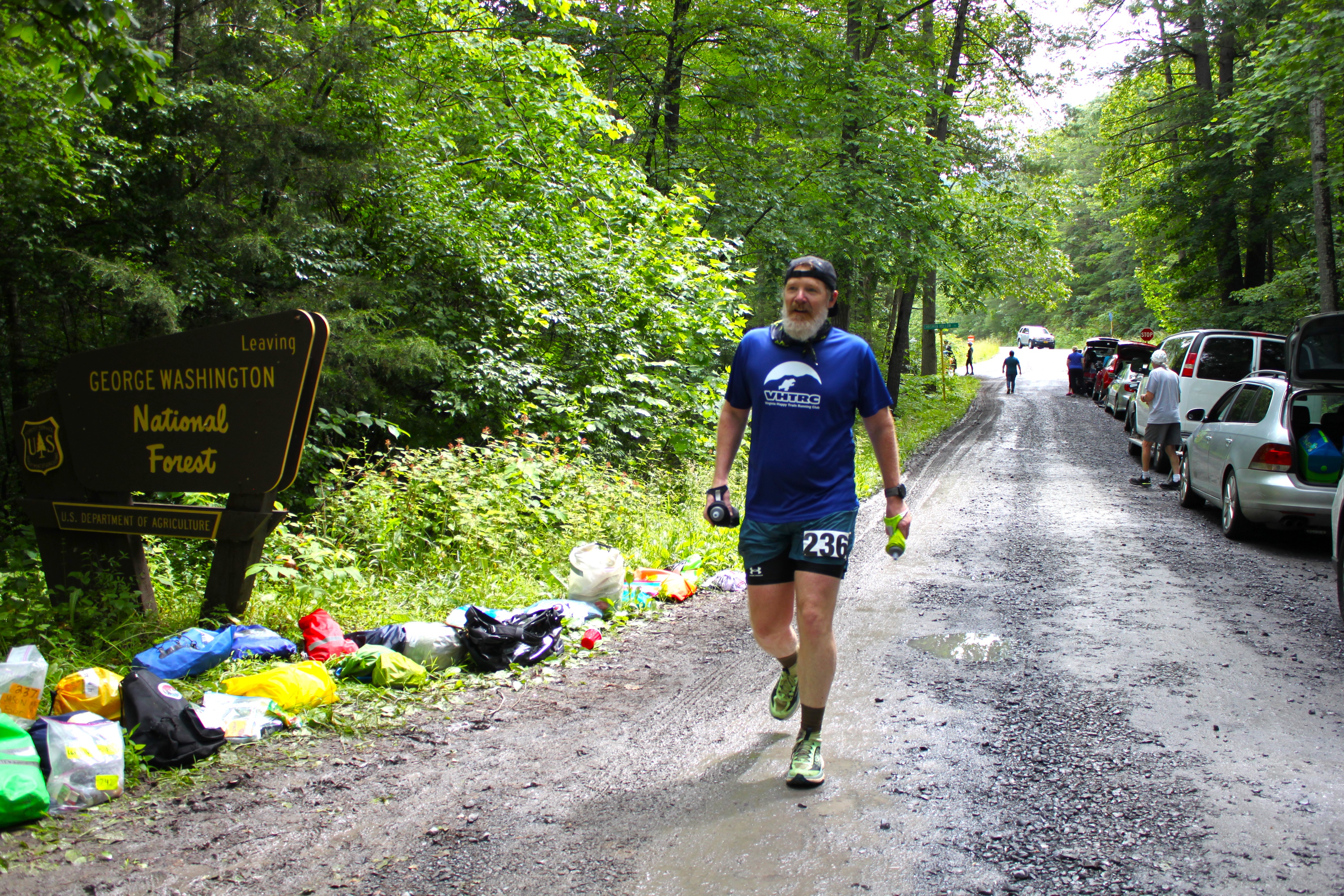 Male runner 
            walking into aid station
