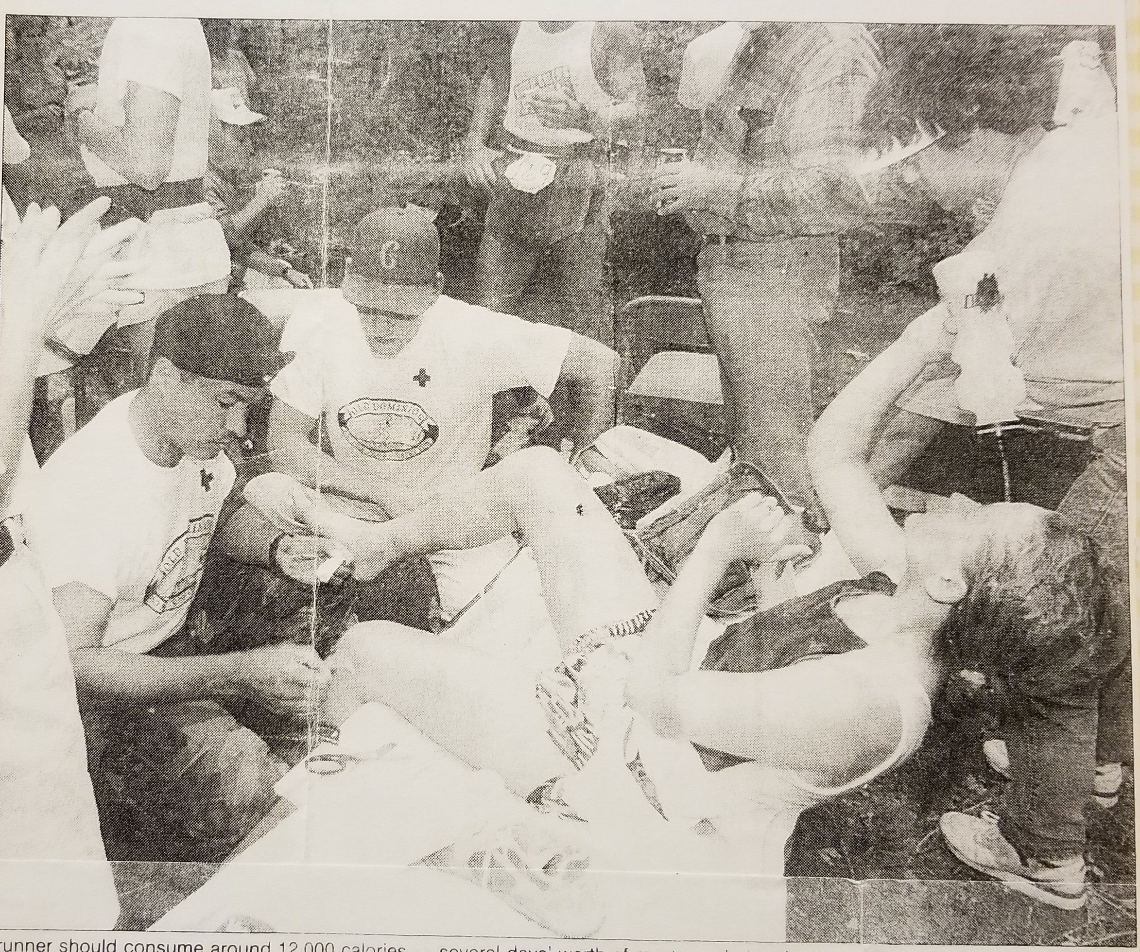 photo from newspaper, runner being looked at by medical team